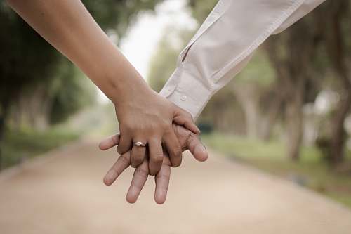 holding hands shallow focus photography of two person holding hands love